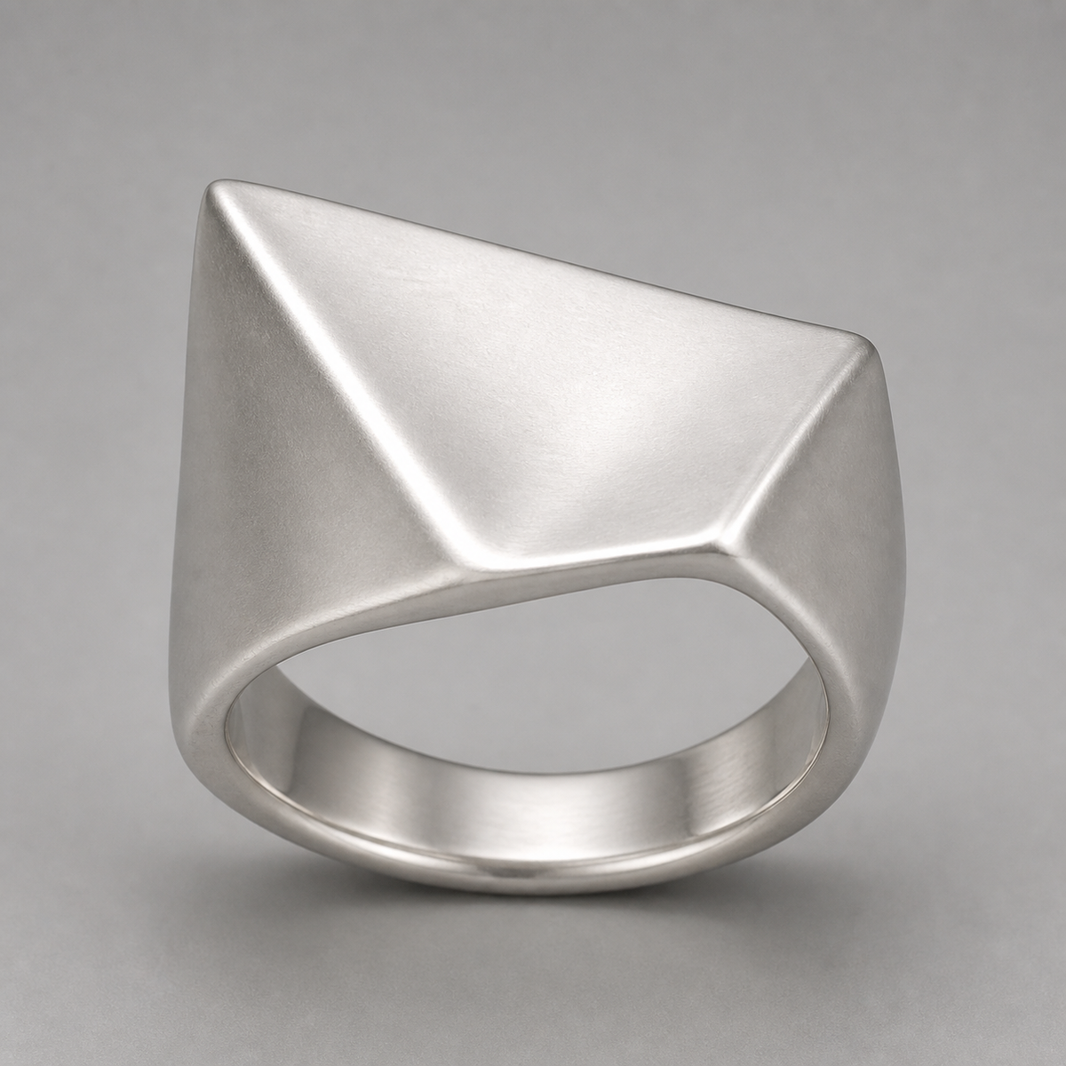 Folded Plane Ring in sterling silver on a neutral studio background